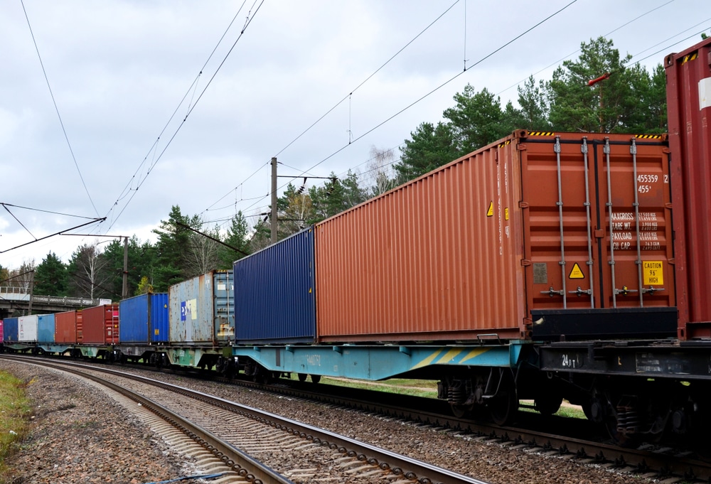 A train moves intermodal containers along a railway.
